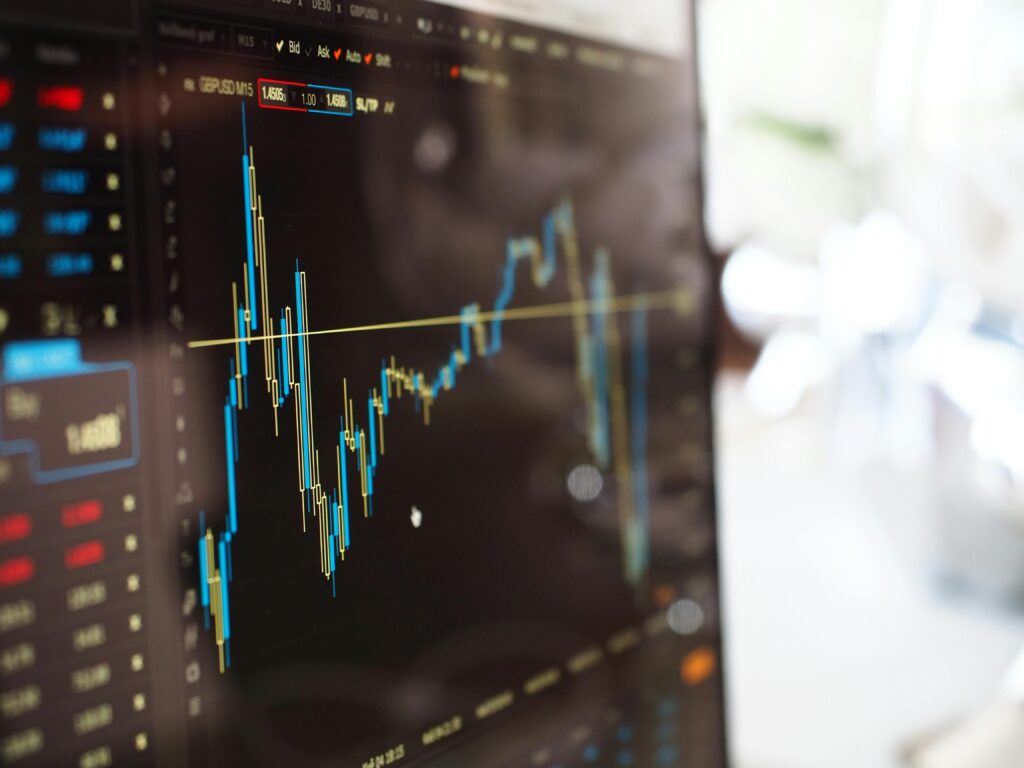 Close-up of a computer screen displaying a financial trading chart with fluctuating candlesticks.